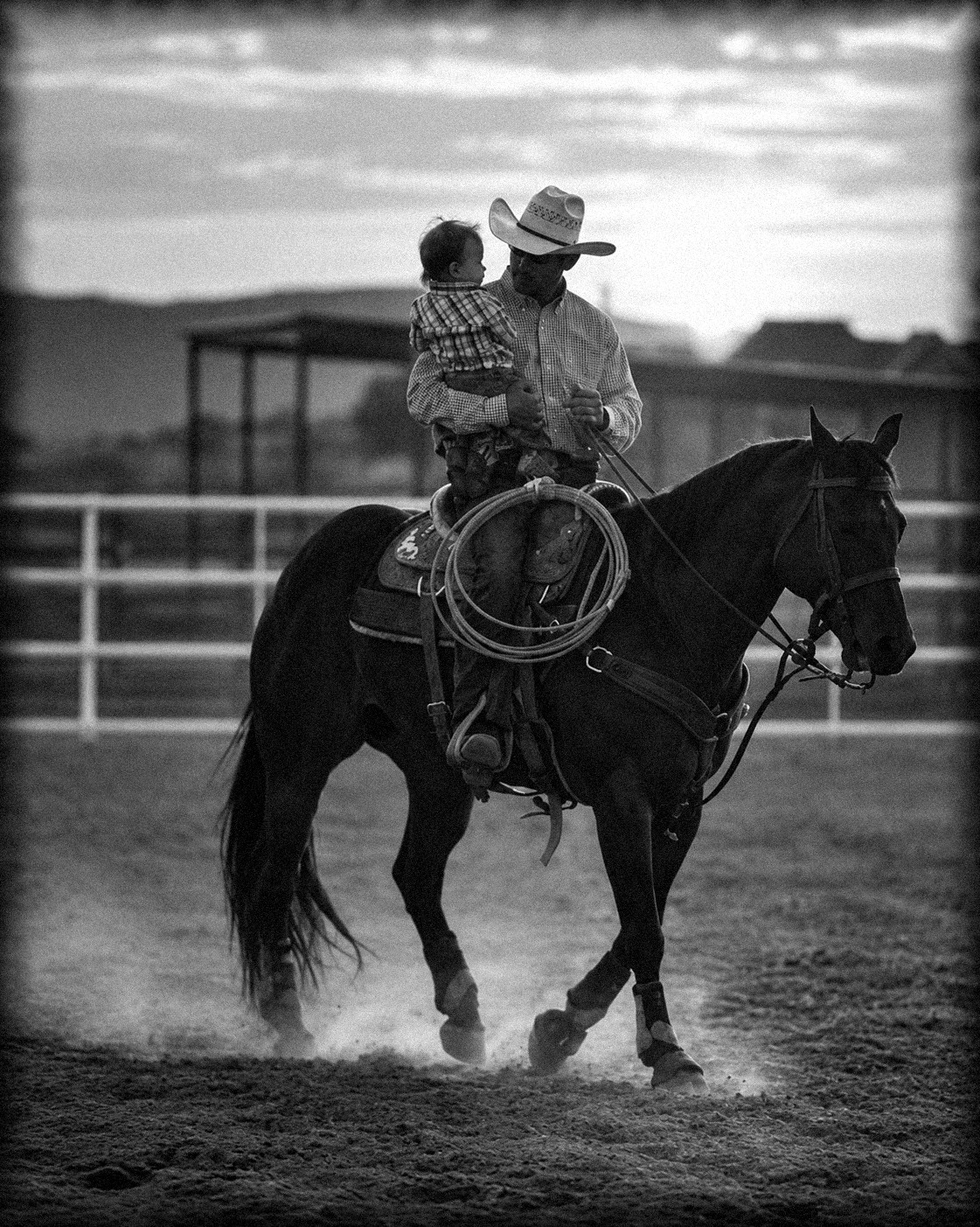 Padre cargando a su hijo a caballo al atardecer