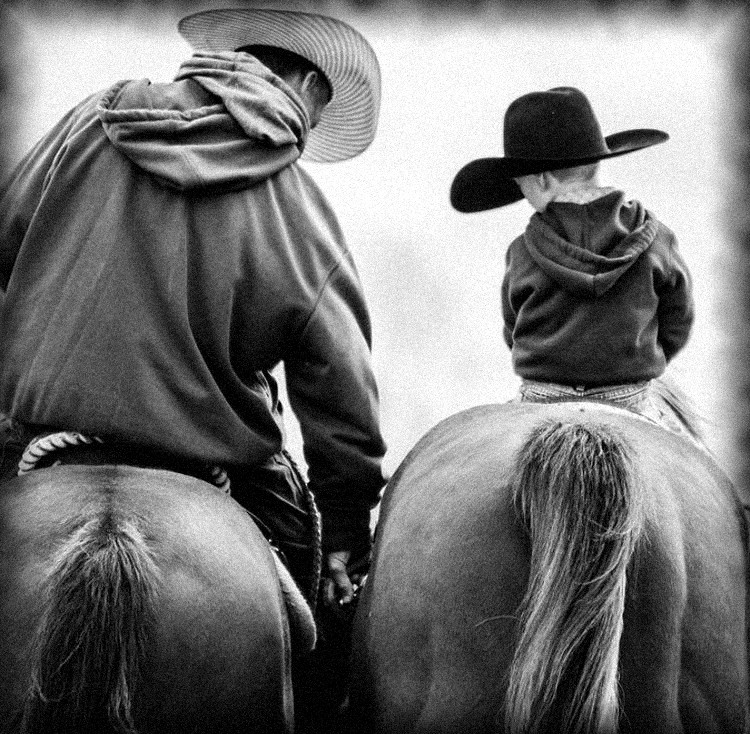 Padre e hijo a caballo, de espaldas